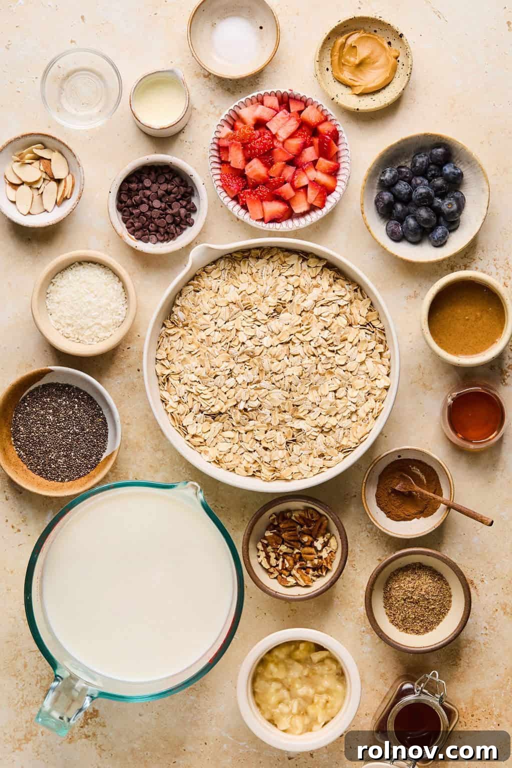 6 Simple Overnight Oats to Master Your Mornings 4 Rolled oats, milk, maple syrup, chia seeds, berries and other ingredients arranged on a surface.