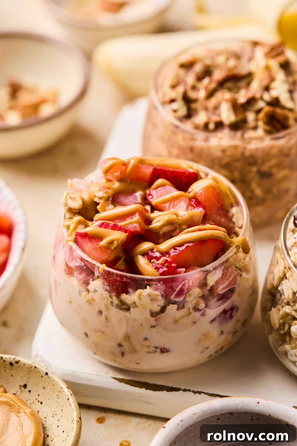 6 Simple Overnight Oats to Master Your Mornings 9 Pb and J oatmeal in dish topped with strawberries and a drizzle of peanut butter.