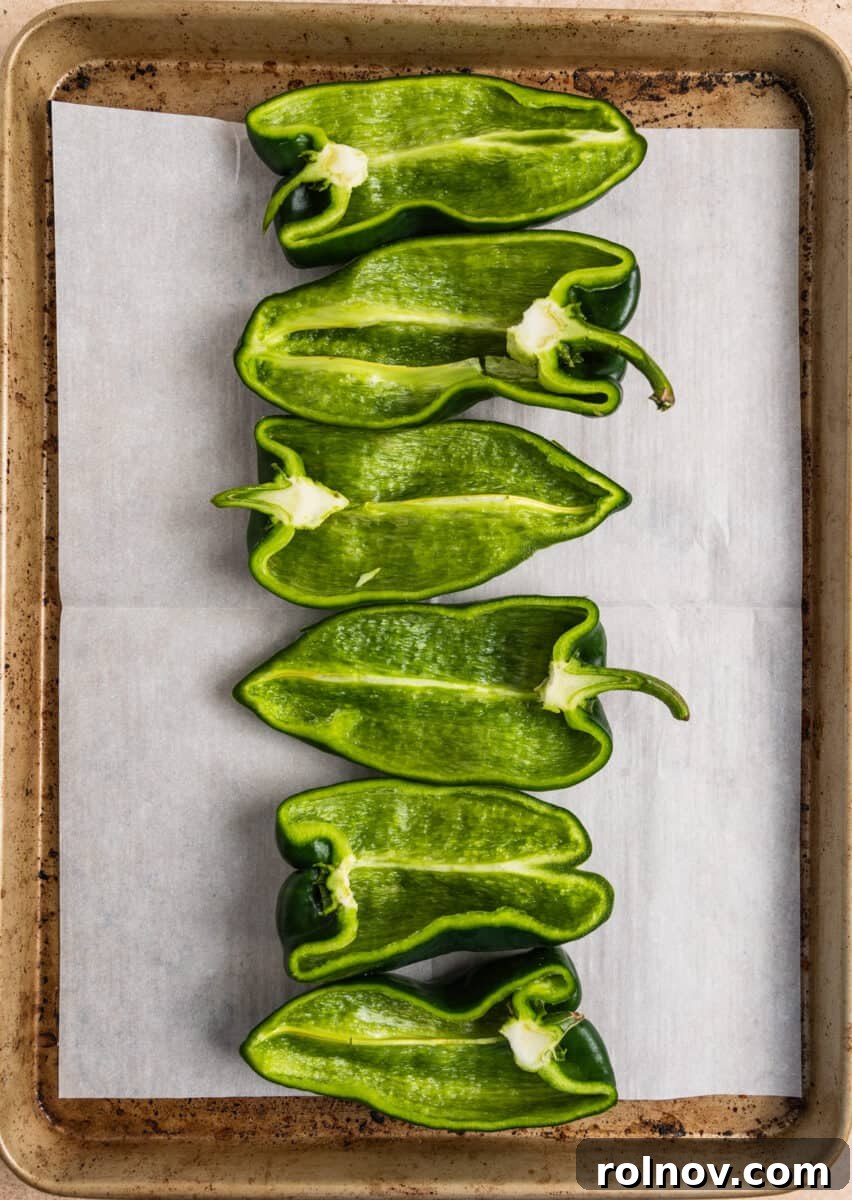 Savory Chicken Poblano Boats 5 Poblano peppers, halved and prepared, arranged on a parchment-lined baking sheet before stuffing.