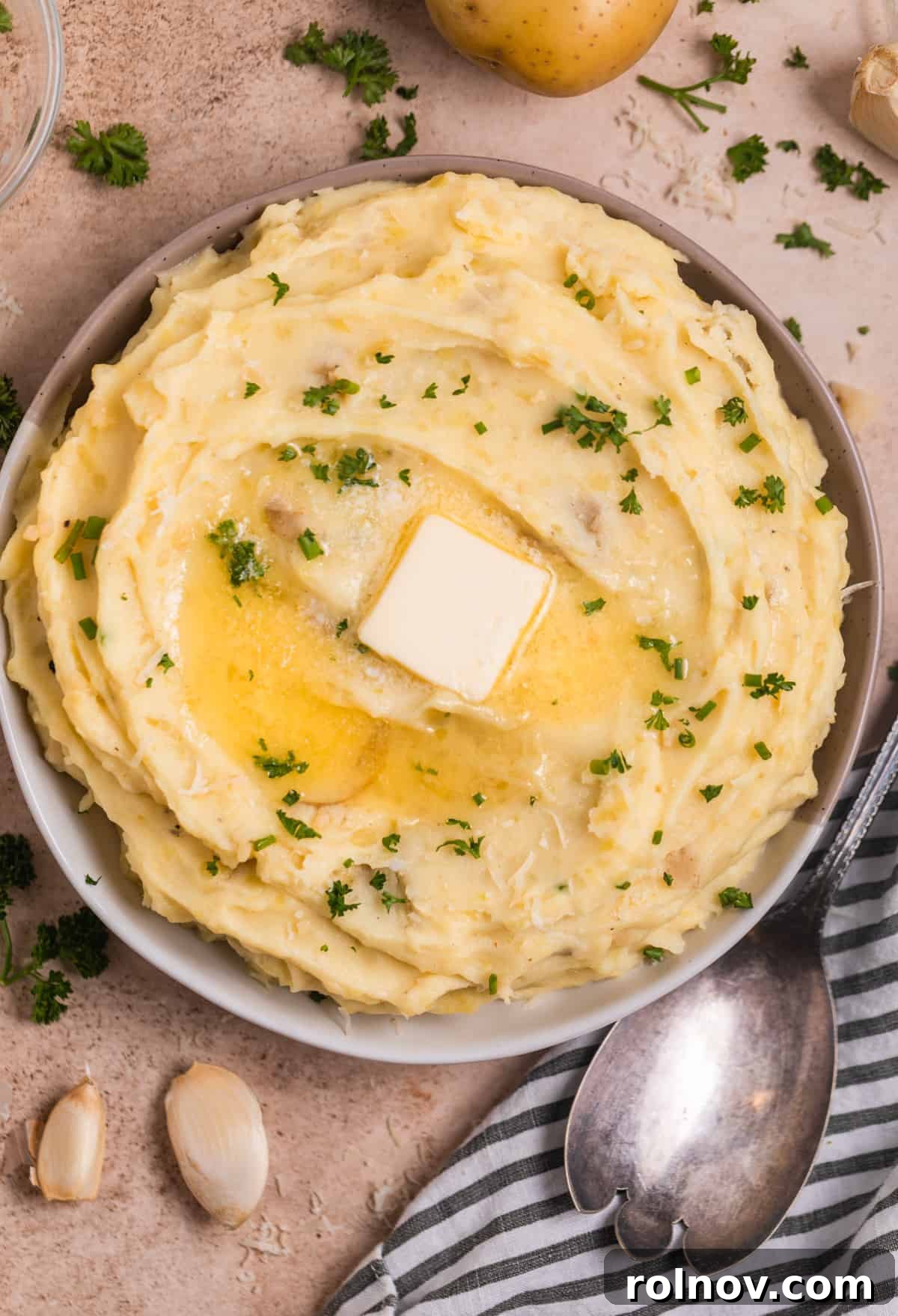 Creamy Instant Pot Garlic Parmesan Mashed Potatoes 2 Bowl of Instant Pot mashed potatoes topped with butter, chopped parsley, and chives.
