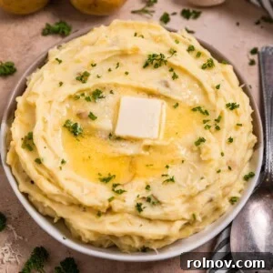 Creamy Instant Pot Garlic Parmesan Mashed Potatoes 8 Garlic parmesan mashed potatoes in serving dish with melted butter over top.