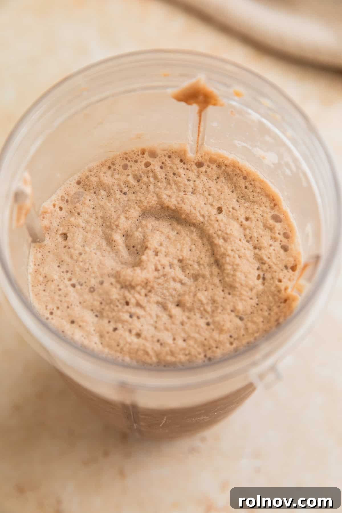 Decadent Homemade Mocha Frappuccino 5 A blended coffee drink is seen in the blender cup, showcasing the smooth, frothy texture after blending.
