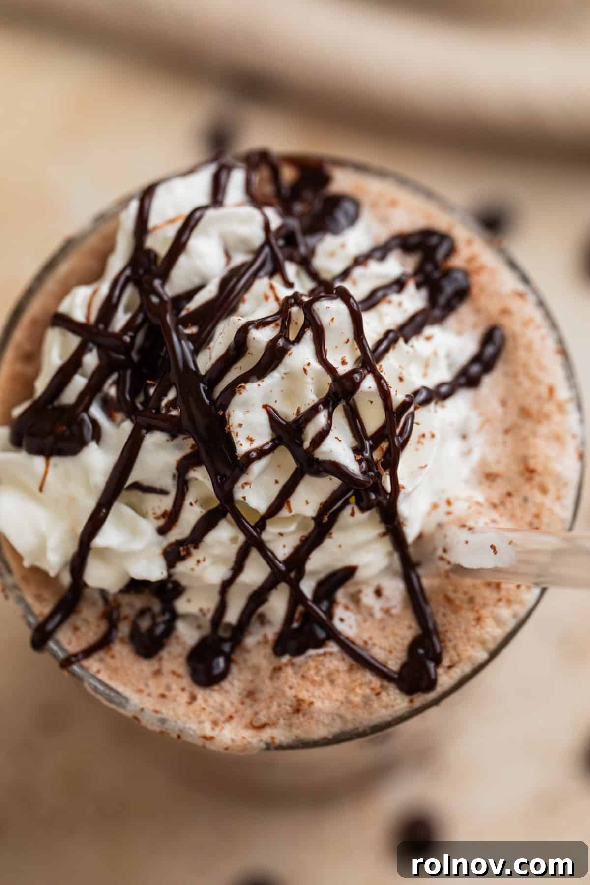 Decadent Homemade Mocha Frappuccino 6 Homemade frappuccino in a glass, generously topped with whipped cream and a delicate chocolate drizzle.