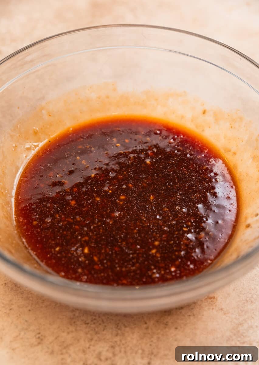 One-Pan Honey Garlic Chicken Thigh Dinner 4 Honey garlic sauce whisked together in glass mixing bowl.
