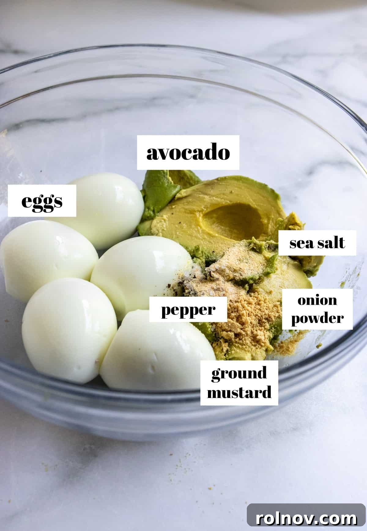 Creamy Avocado Egg Salad 3 Freshly hard-boiled eggs, ripe avocados, and a sprinkle of seasonings in a glass mixing bowl, ready to be combined for a delicious avocado egg salad.