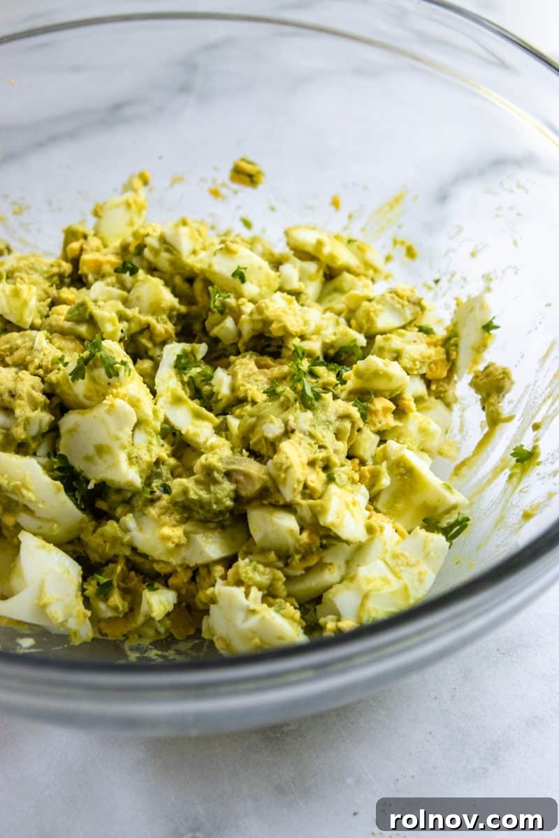 Creamy Avocado Egg Salad 4 A close-up shot of creamy Avocado Egg Salad in a bowl, showing its vibrant green hue and inviting texture, ready to be served.