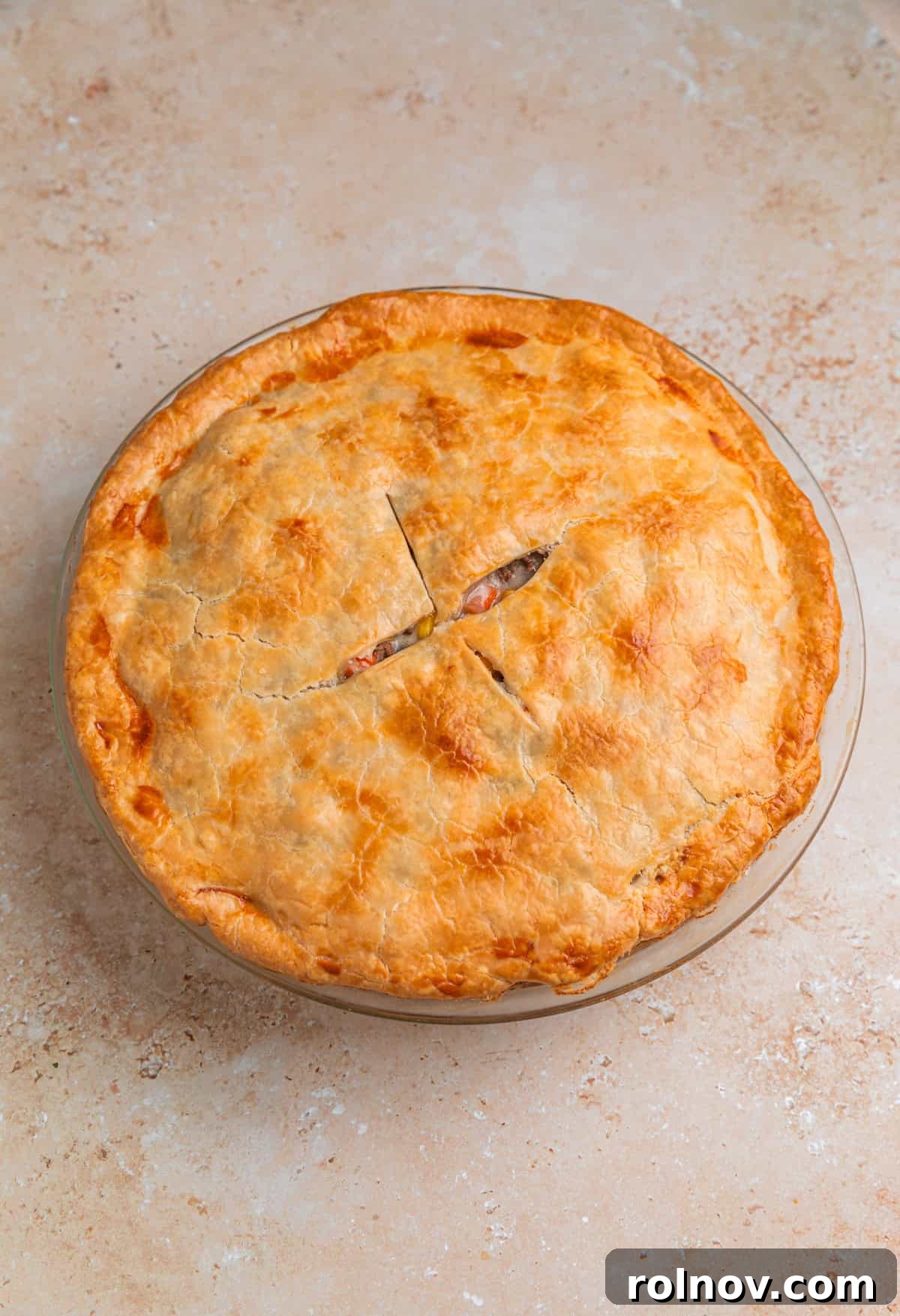 Hearty Beef Pot Pie 11 A freshly baked ground beef pot pie, golden and bubbly, still in its pie dish straight from the oven, ready to cool.
