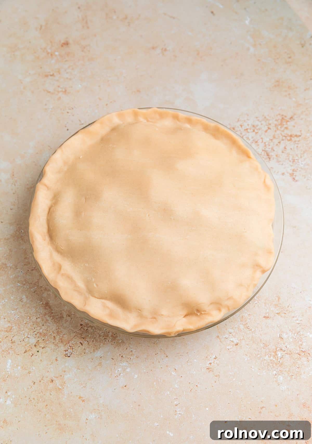 Hearty Beef Pot Pie 9 The second pie crust carefully placed over the filling, ready for sealing and crimping to complete the pot pie.