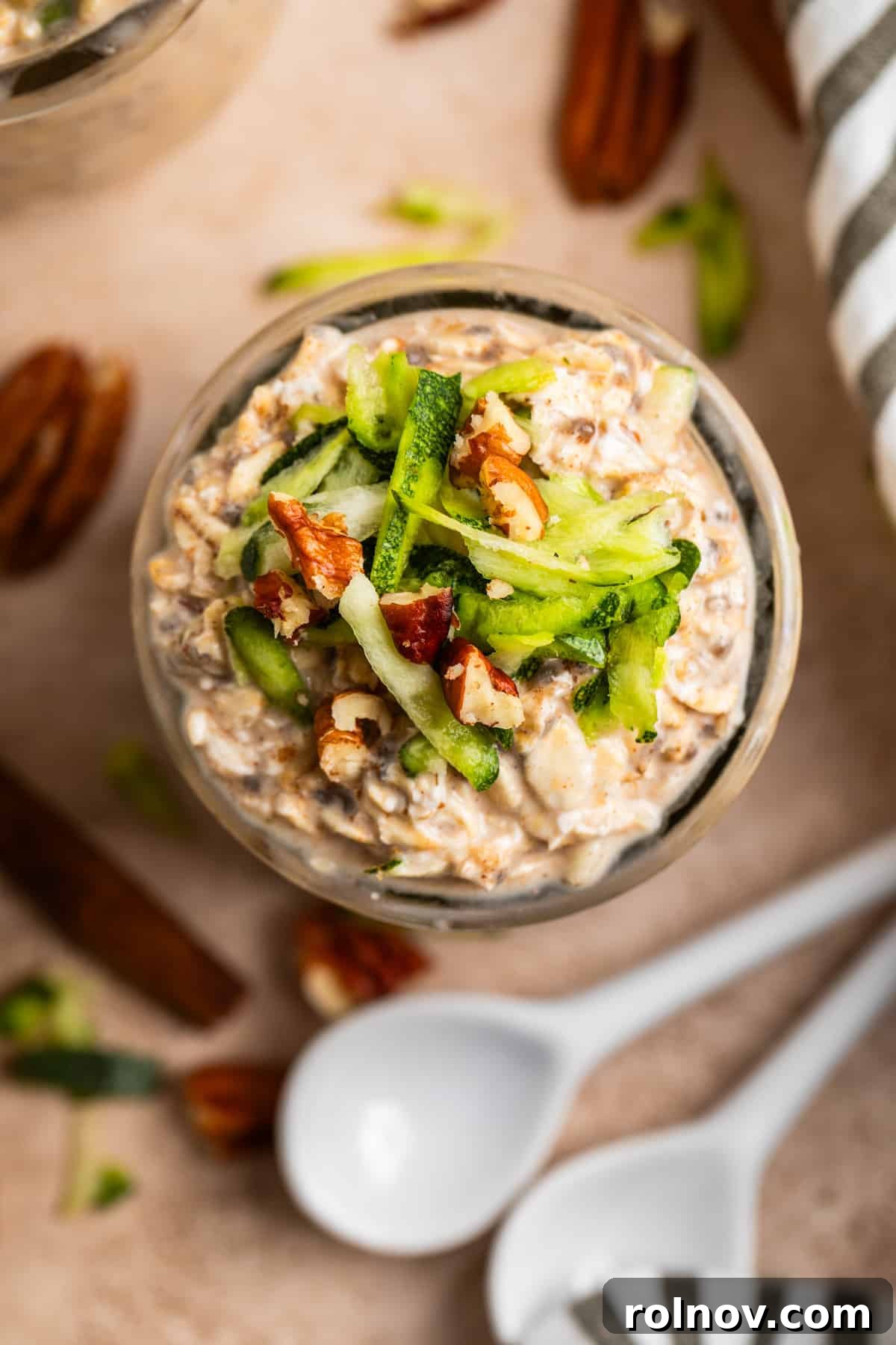 No-Bake Zucchini Bread Breakfast 3 Overhead view of jar with oatmeal topped with zucchini and pecans.