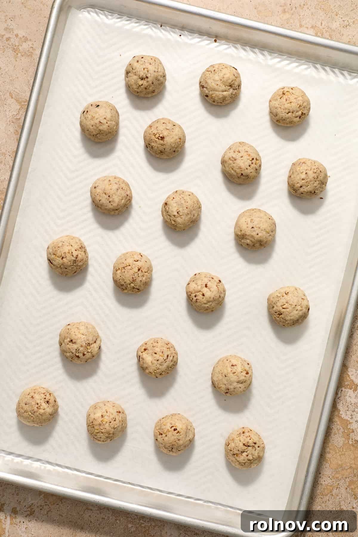 Velvety Pecan Cream Cheese Snowflakes 12 Baked Christmas snowball cookies on baking sheet.