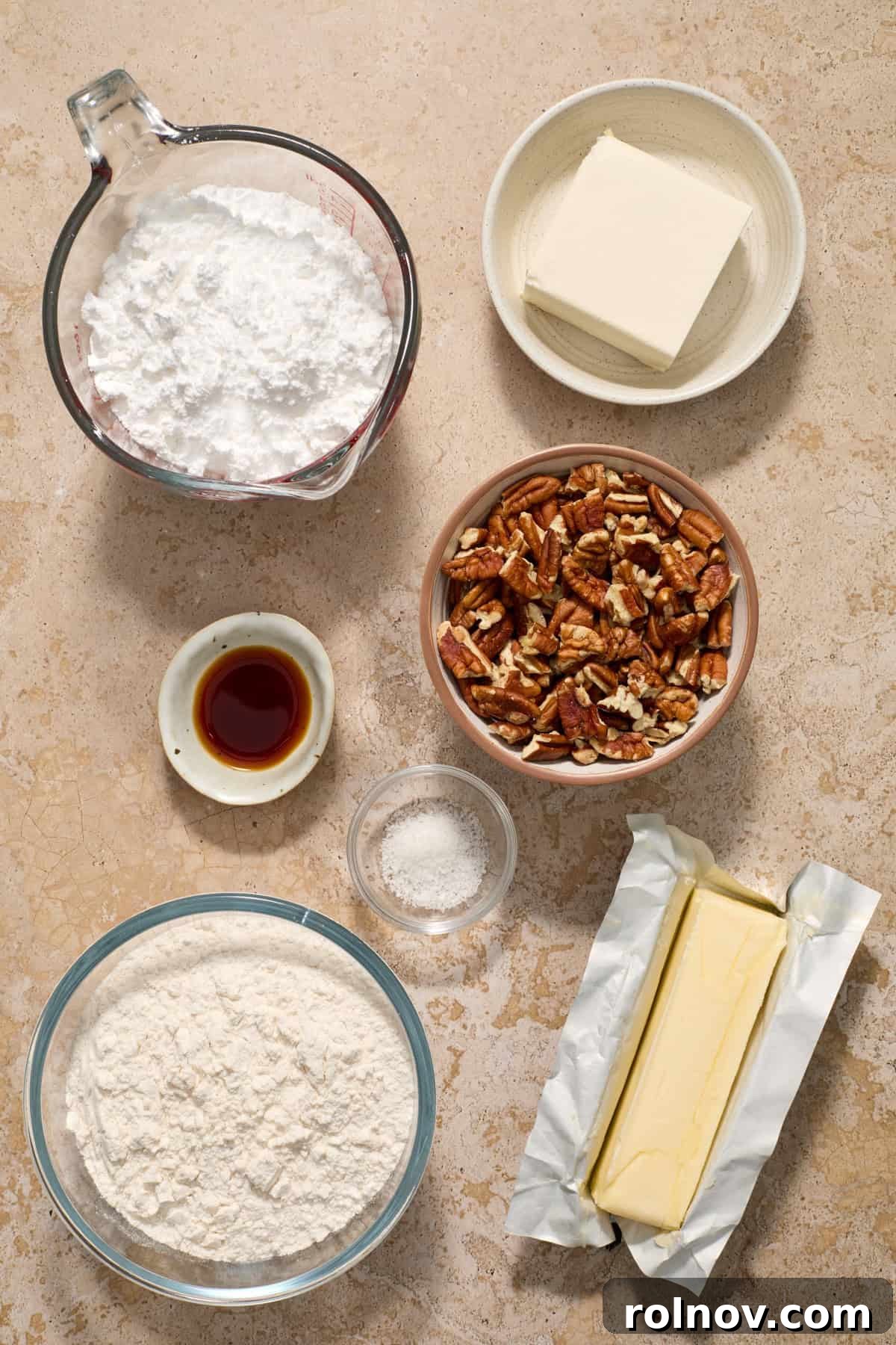 Velvety Pecan Cream Cheese Snowflakes 4 Butter, pecans, cream cheese, vanilla extract, flour and other ingredients arranged in bowls on surface.