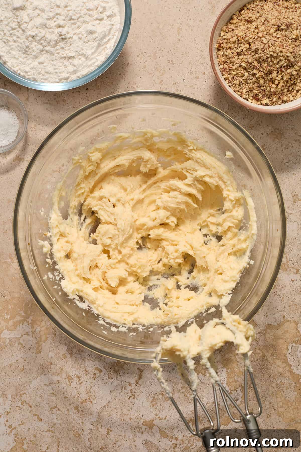 Velvety Pecan Cream Cheese Snowflakes 8 Vanilla added to creamed butter and sugar with flour and crushed pecans beside bowl.