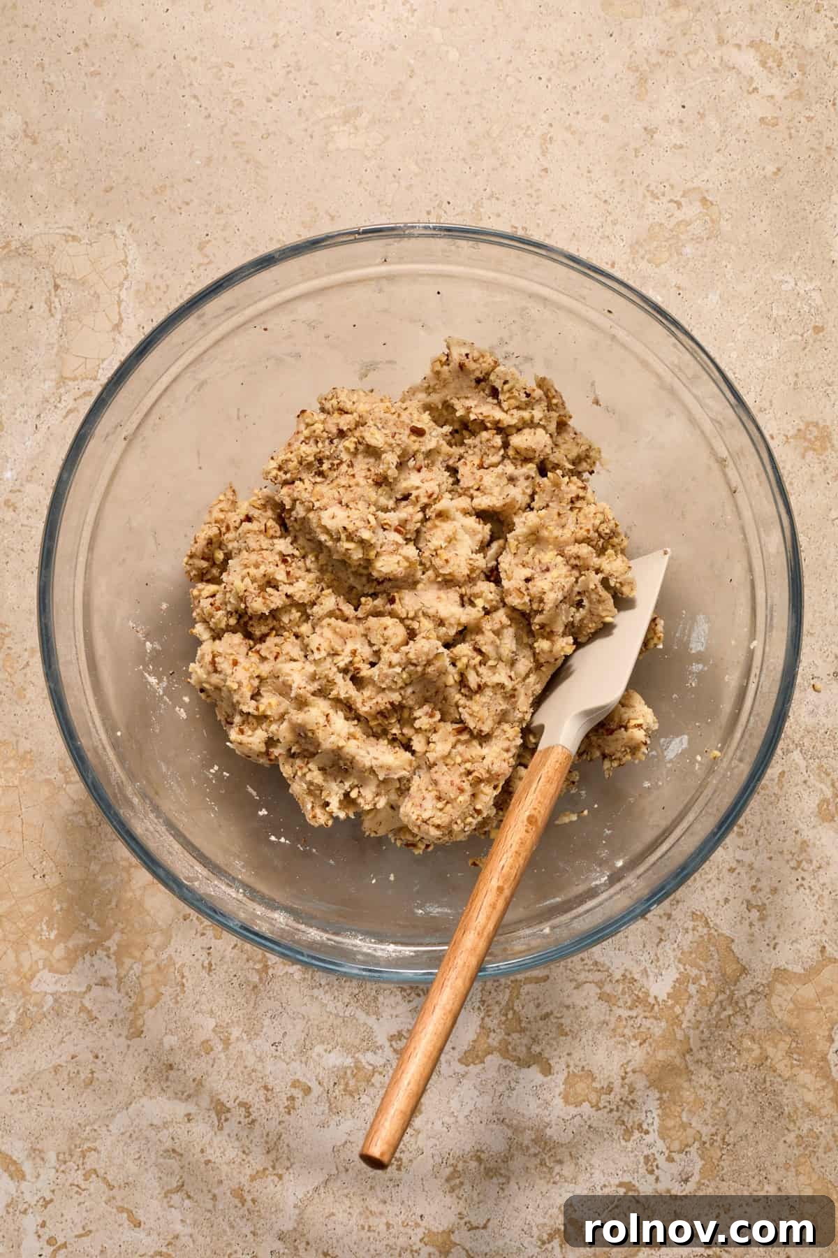 Velvety Pecan Cream Cheese Snowflakes 10 Pecan snowball cookie dough in glass bowl with spatula.