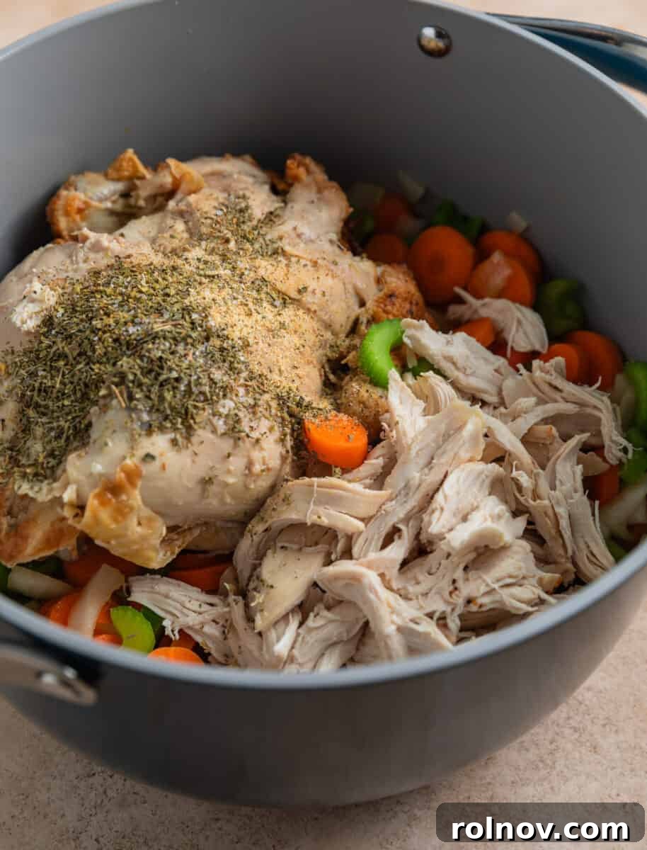 Shortcut Rotisserie Chicken Noodle Soup 6 Shredded rotisserie chicken and the chicken carcass added to the pot with the cooked carrots, celery, and onion, ready for broth.