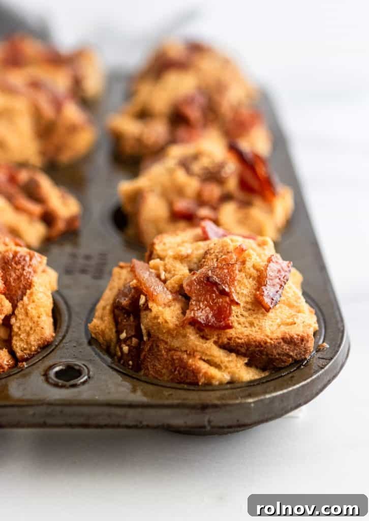 A muffin tin holds freshly baked Maple Bacon French Toast Muffins, golden brown and ready to be enjoyed, promising a perfect blend of sweet and savory.