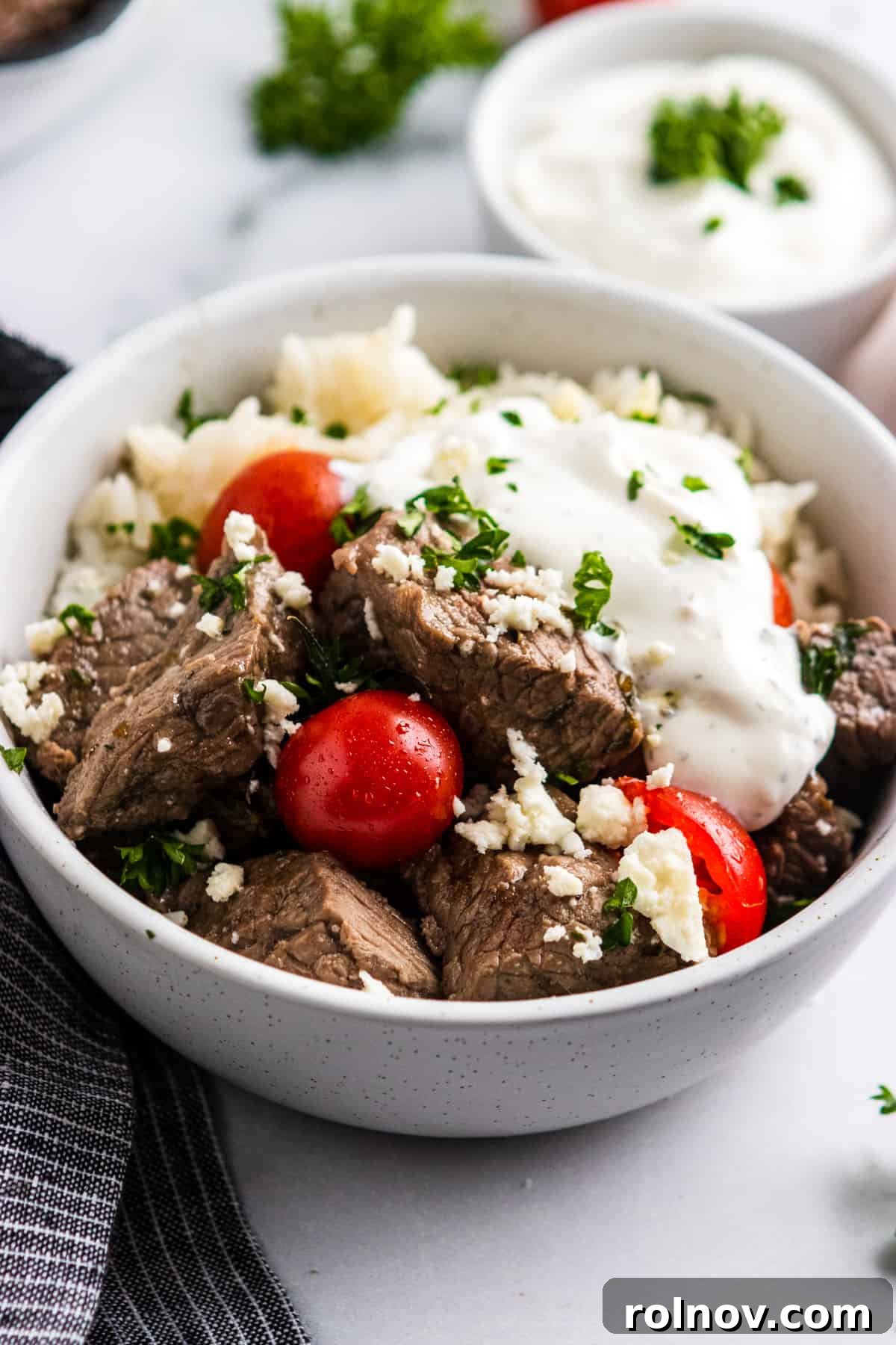 Rice bowl with steak, tomatoes, feta and yogurt dill sauce.