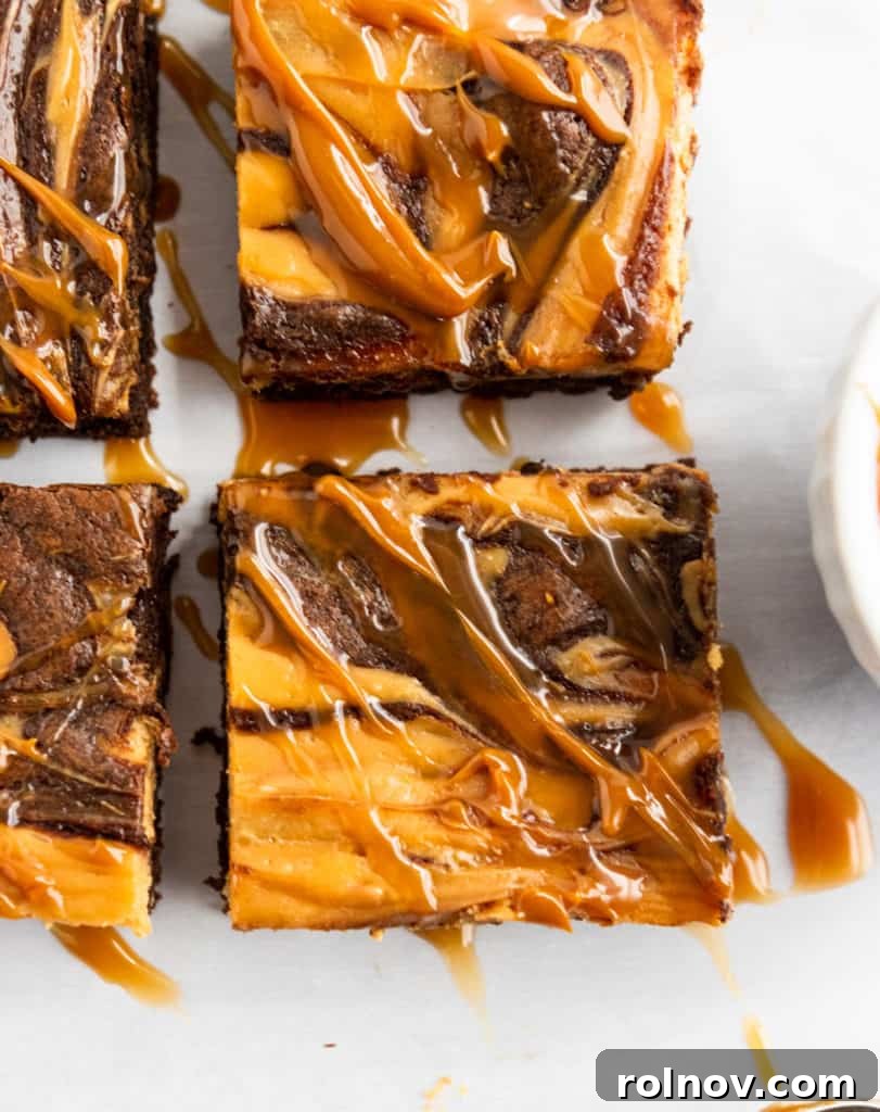 Close up of Cheesecake swirl brownies with dulce de leche drizzle. A tightly cropped image of a brownie, highlighting the intricate swirl pattern where the dark brownie and light dulce de leche cheesecake layers meet, topped with a luscious drizzle.