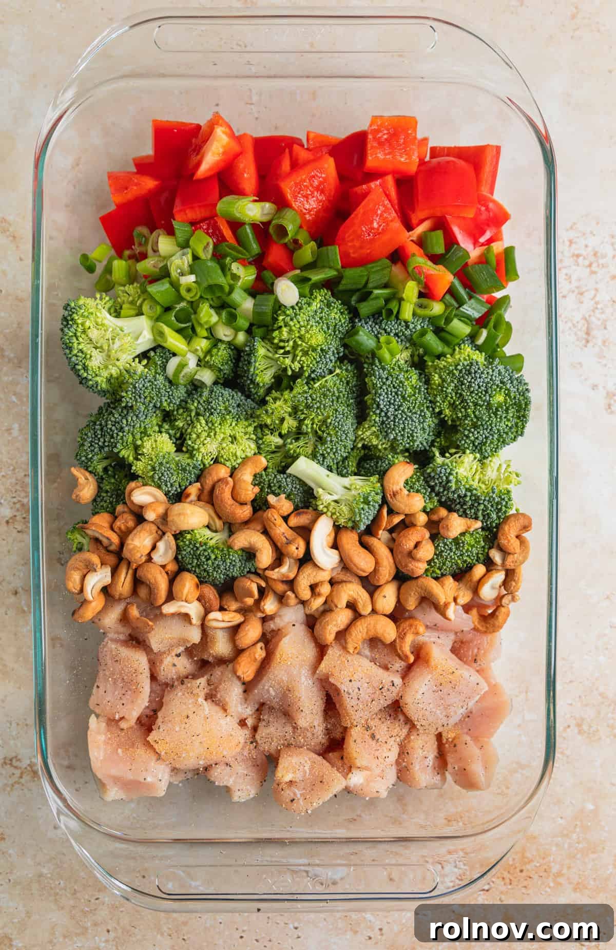 Golden Baked Cashew Chicken 6 Red bell pepper, broccoli, green onion, cashews and chicken in baking pan.
