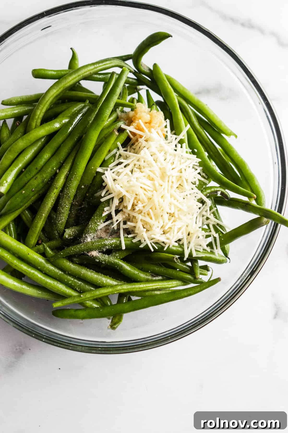 Crispy Roasted Parmesan Green Beans 6 A collection of fresh ingredients laid out: green beans, garlic, olive oil, parmesan, and seasonings, ready for cooking.