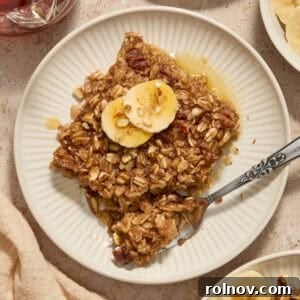 A serving of Banana Bread Baked Oatmeal on a plate, topped with fresh banana slices.