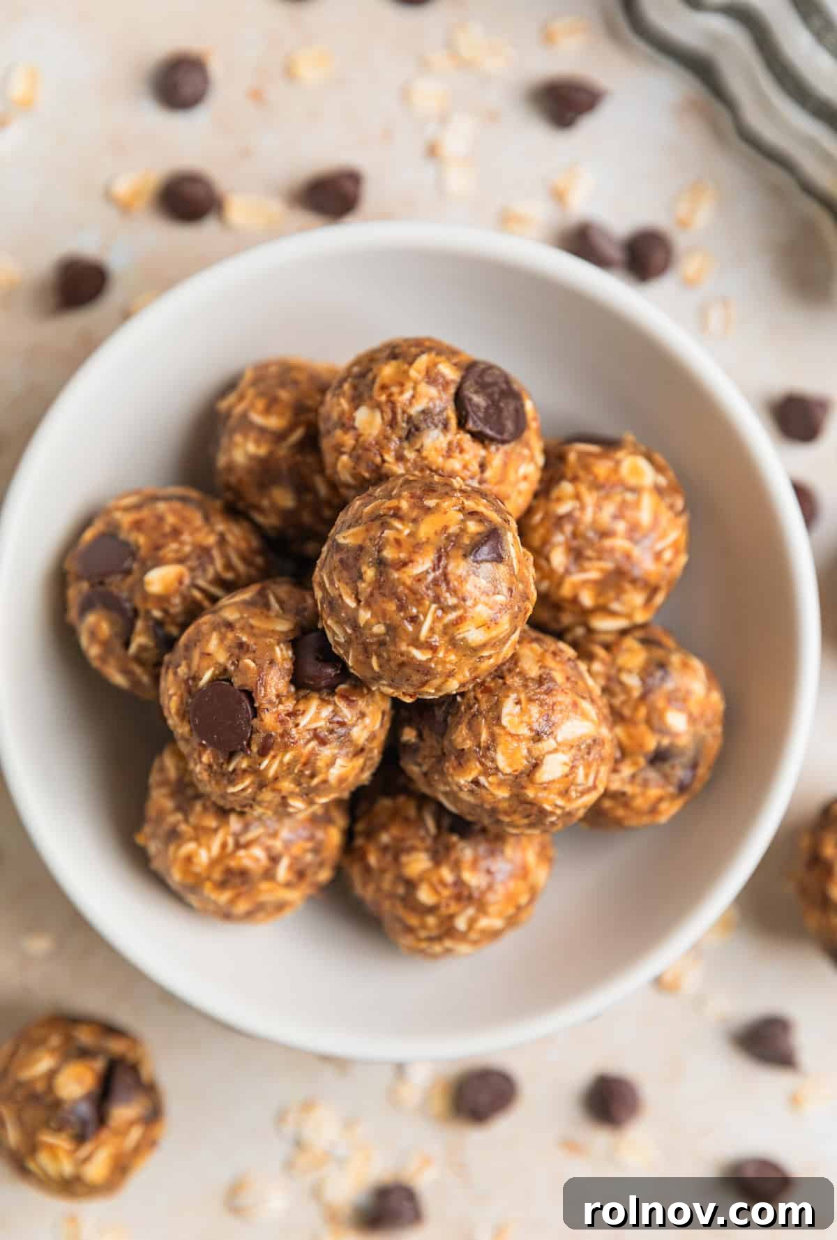 Peanut Butter Oatmeal Energy Bites 3 Close-up of a white dish holding peanut butter oatmeal balls, with visible dark chocolate chips embedded within.