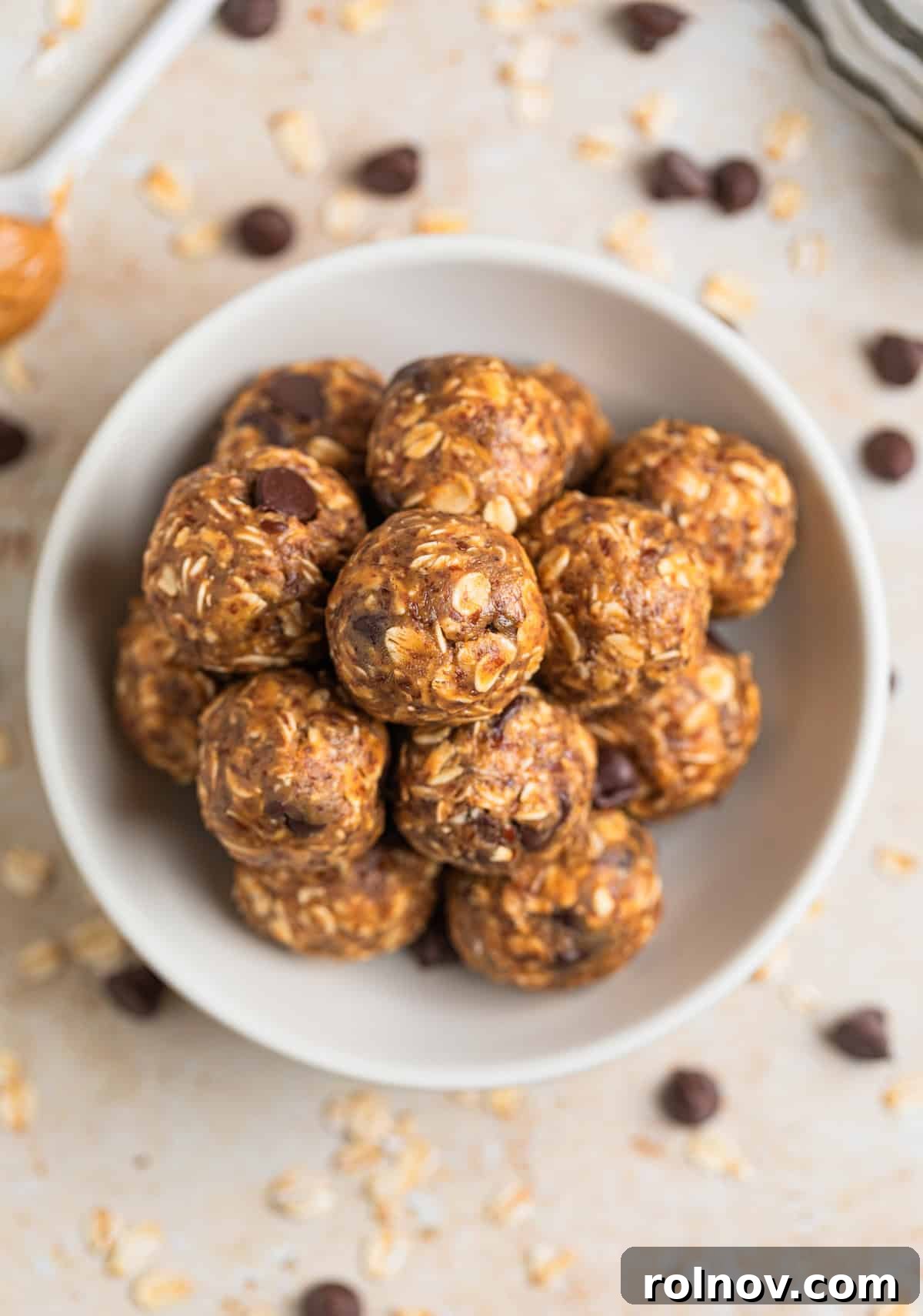 Peanut Butter Oatmeal Energy Bites 8 A dish of peanut butter oat bites, with a spoon of creamy peanut butter resting beside it, highlighting the key ingredient.