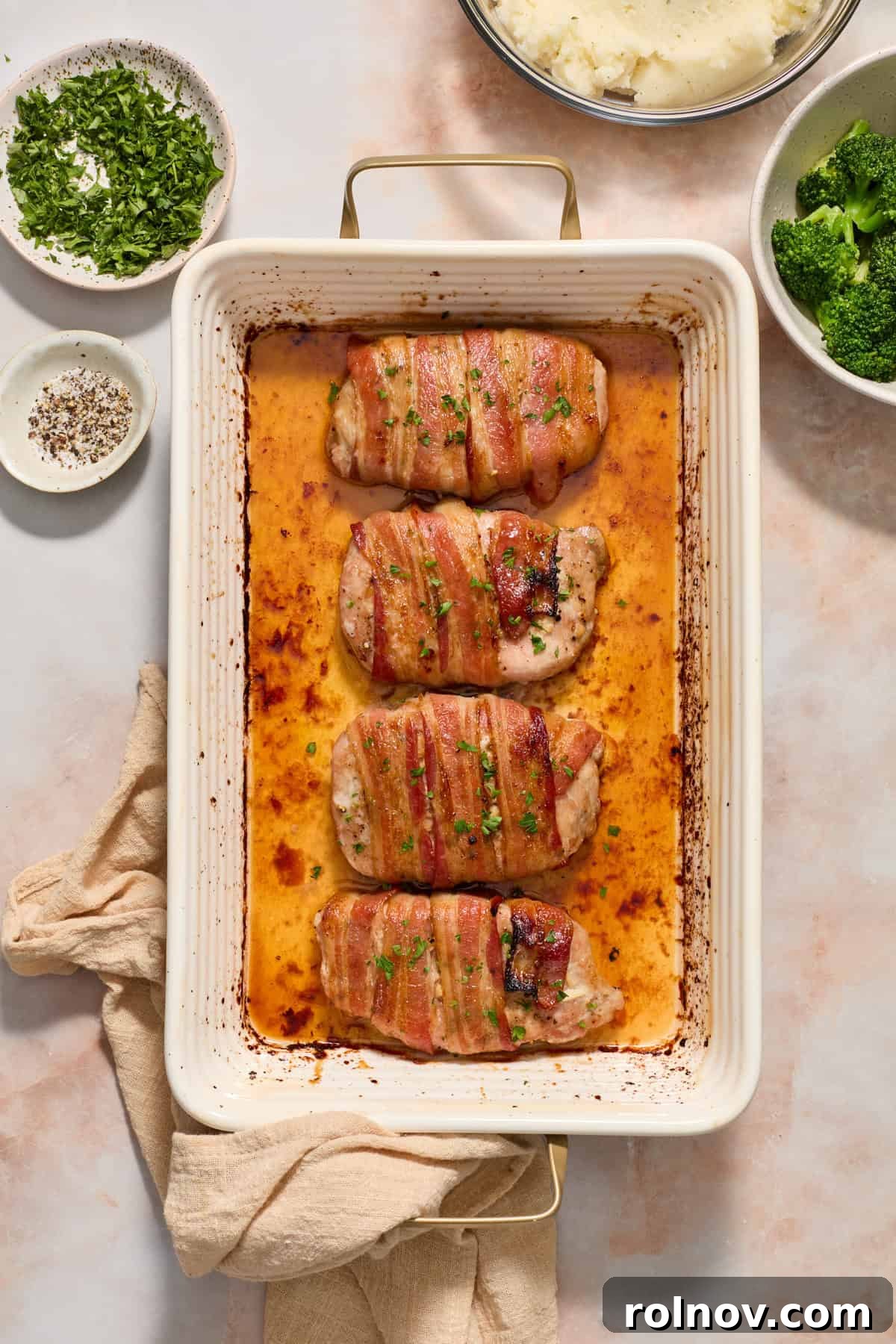 Sweet and Savory Maple Bacon Pork Chops 3 Maple bacon wrapped pork chops in a baking pan, garnished with fresh parsley.