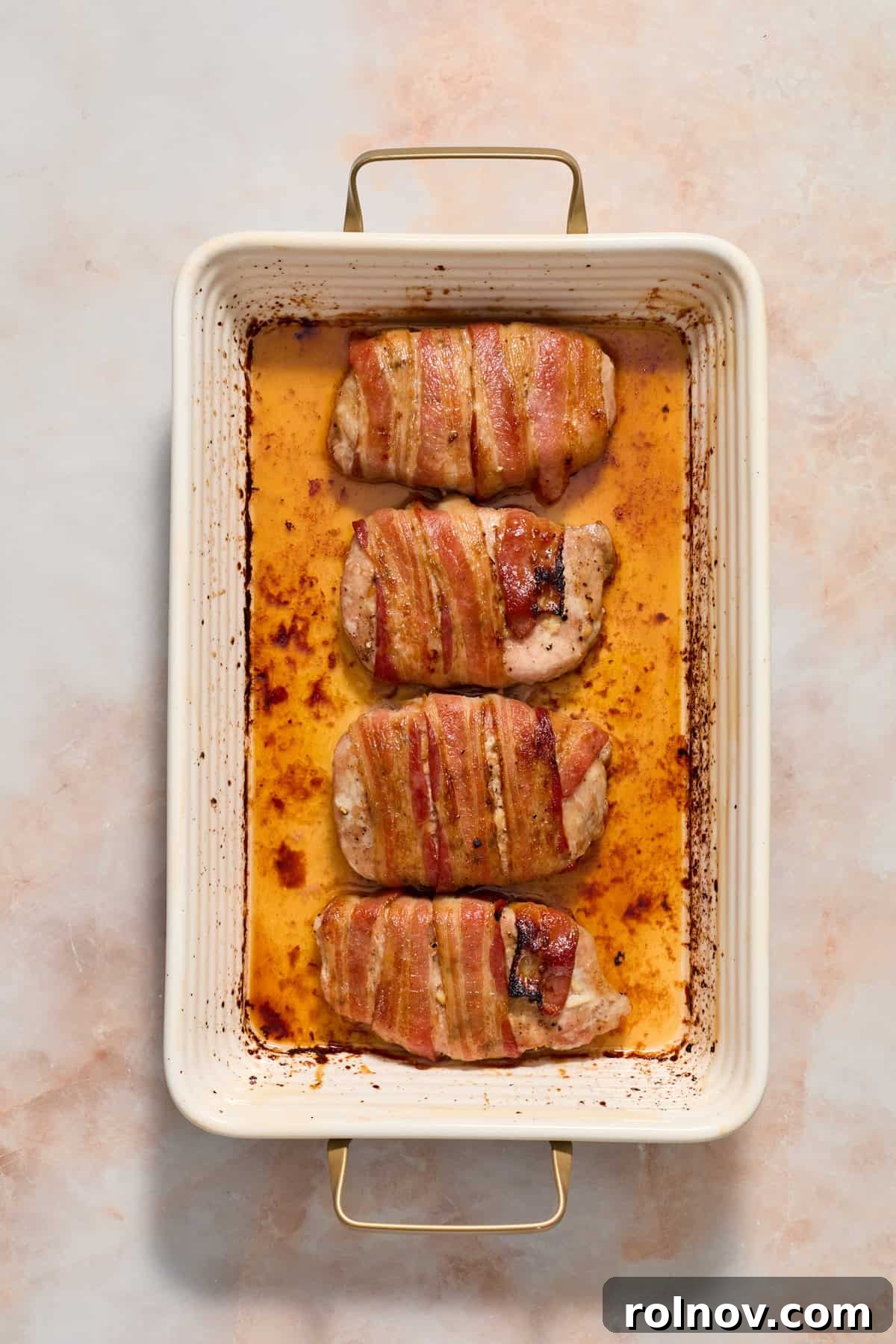 Sweet and Savory Maple Bacon Pork Chops 8 Baked maple bacon wrapped pork chops, golden and caramelized, resting in a baking dish.