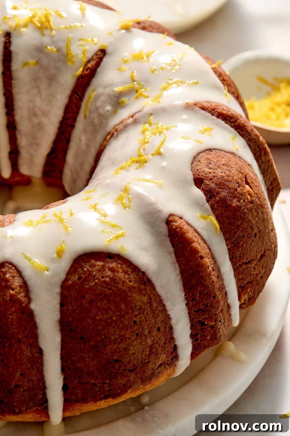 Effervescent Lemon Bundt Cake 2 A stunning Champagne Lemon Bundt Cake adorned with a delicate lemon icing drizzle and fresh lemon zest, ready to impress.