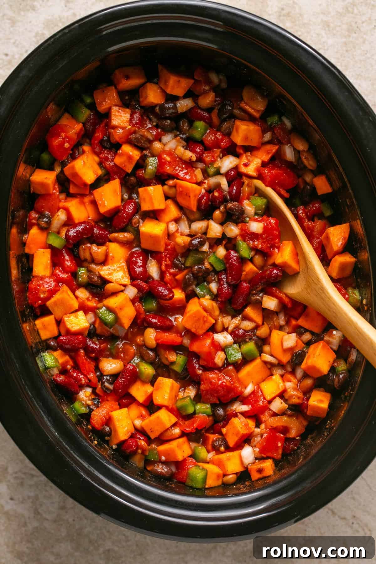 All the slow cooker sweet potato chili ingredients thoroughly stirred together in the crockpot before commencing the cooking process.