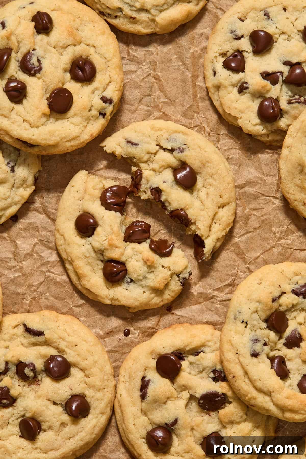 A warm eggless chocolate chip cookie broken in half, revealing gooey melted chocolate inside.