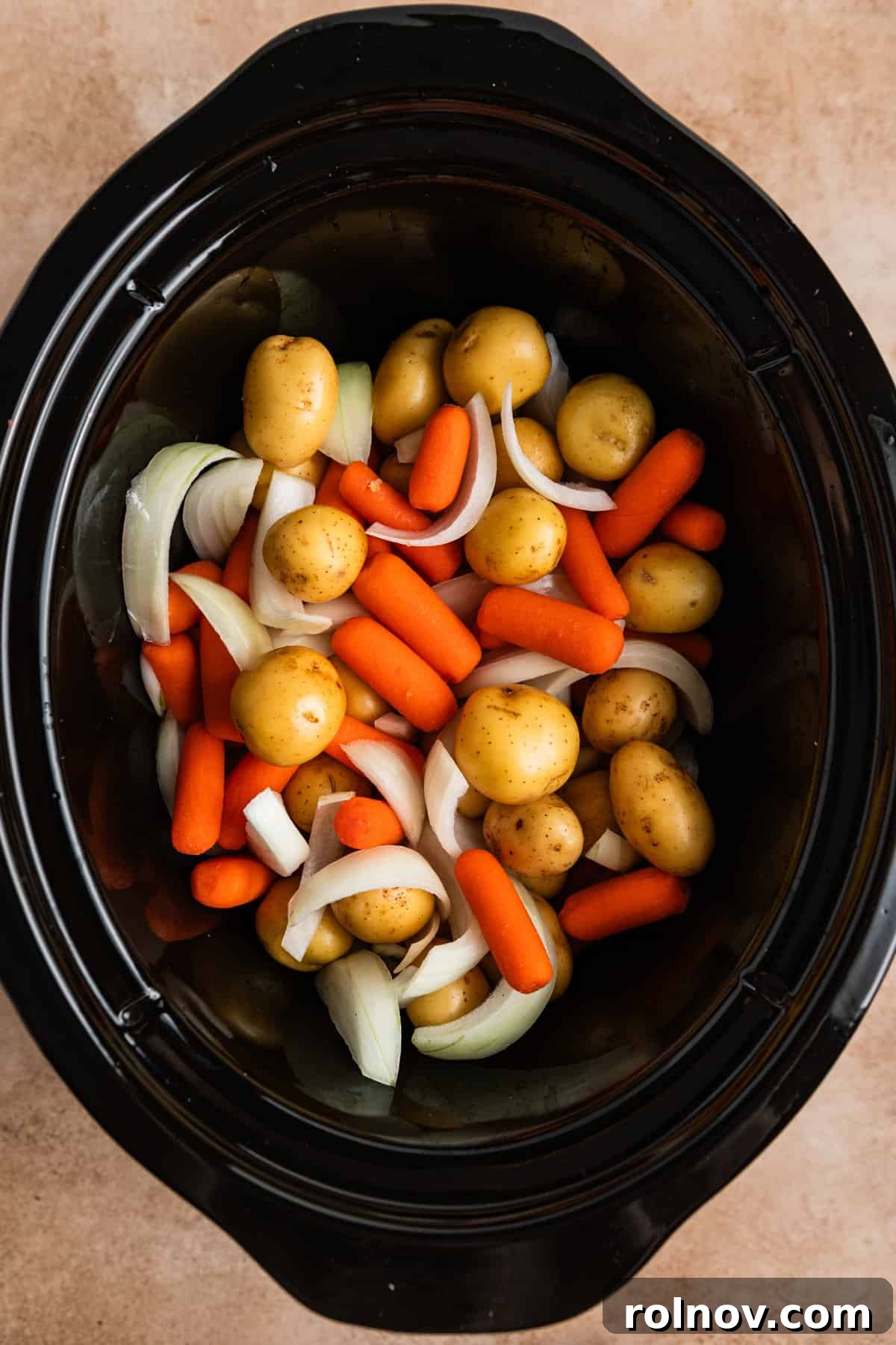 Slow Cooker Beef Pot Roast 5 Carrots, onions and potatoes in crock pot.
