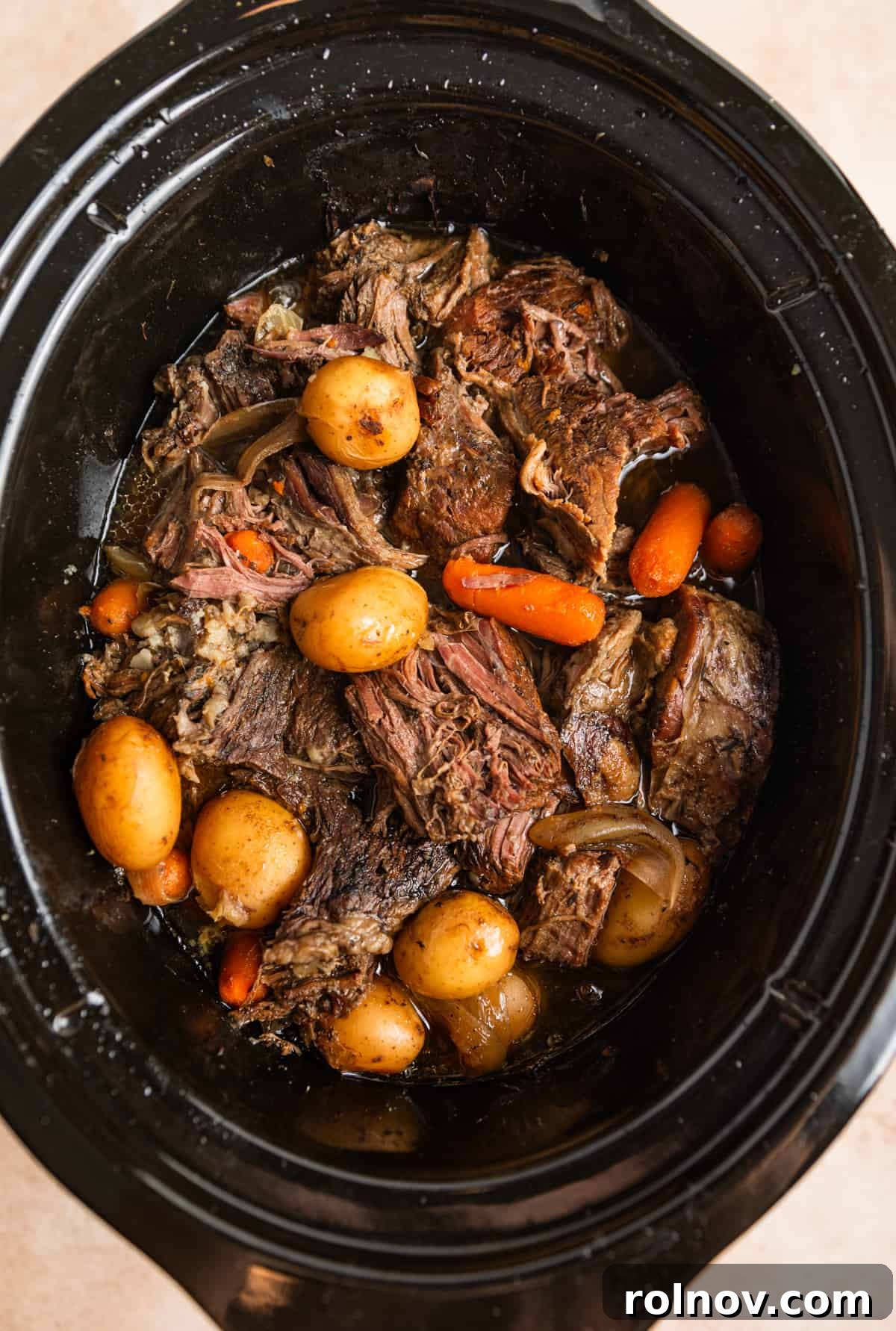 Slow Cooker Beef Pot Roast 9 Chunks of meat, cooked carrots, onions and petite potatoes in slow cooker.