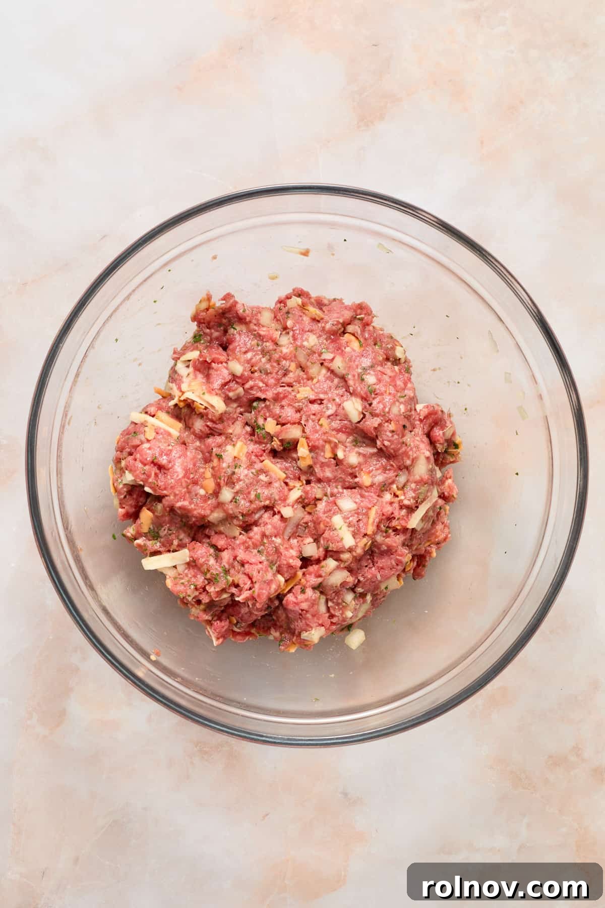 The Ultimate Air Fryer Burger 5 The hamburger mixture, thoroughly combined in a glass bowl, showcasing a uniform texture and even distribution of ingredients.