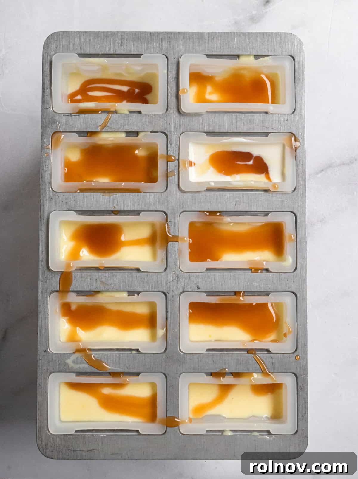 DIY Jello Pudding Pops 4 Popsicle molds filled with a creamy Jello pudding mixture and a touch of caramel.