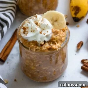 Pumpkin banana overnight oats in jar with whipped cream and cinnamon.