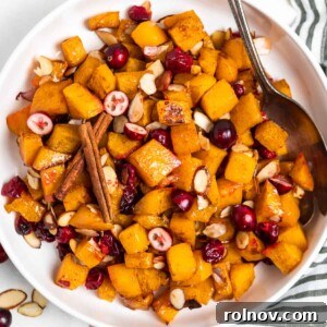 Overhead view of white bowl with maple roasted butternut squash, cranberries, and almonds.