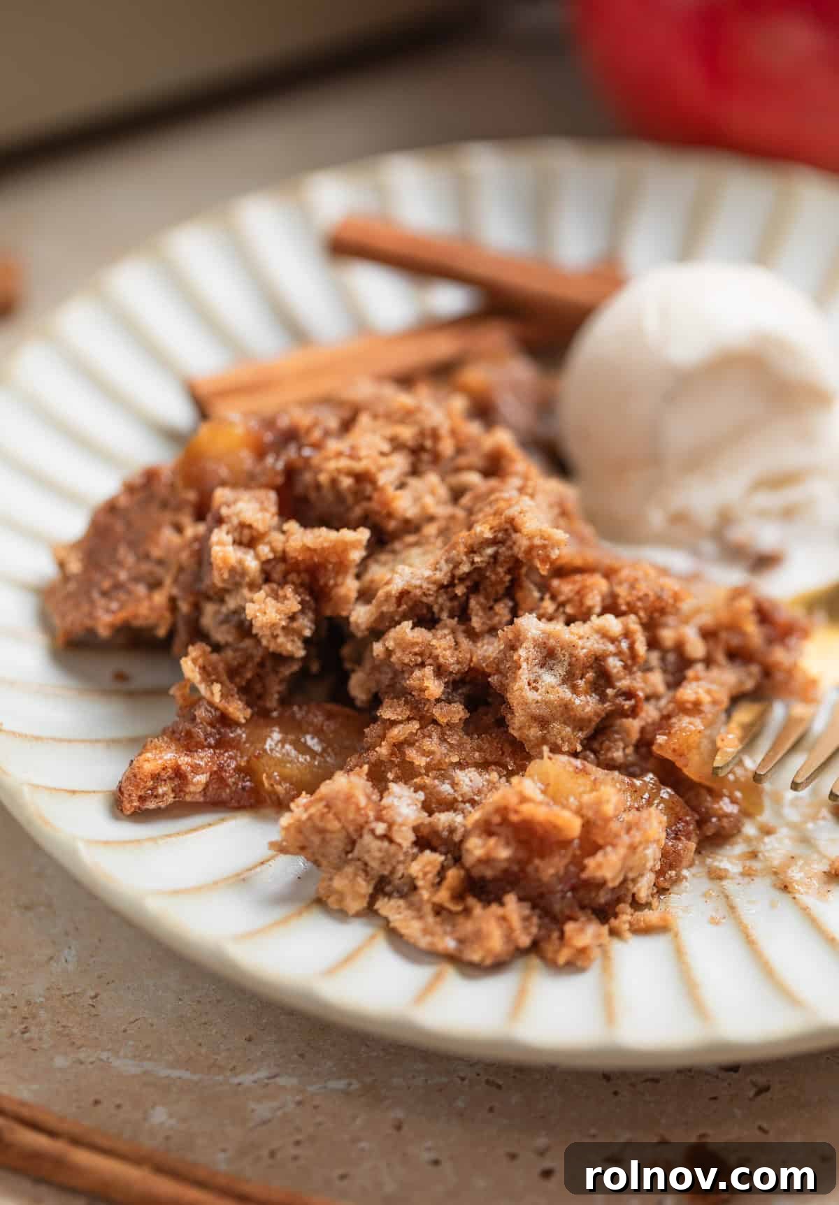 Effortless Golden Apple Bake 3 Cinnamon apple dump cake recipe served on a dish with a generous scoop of vanilla ice cream, showcasing its warm, inviting appeal and crispy topping.