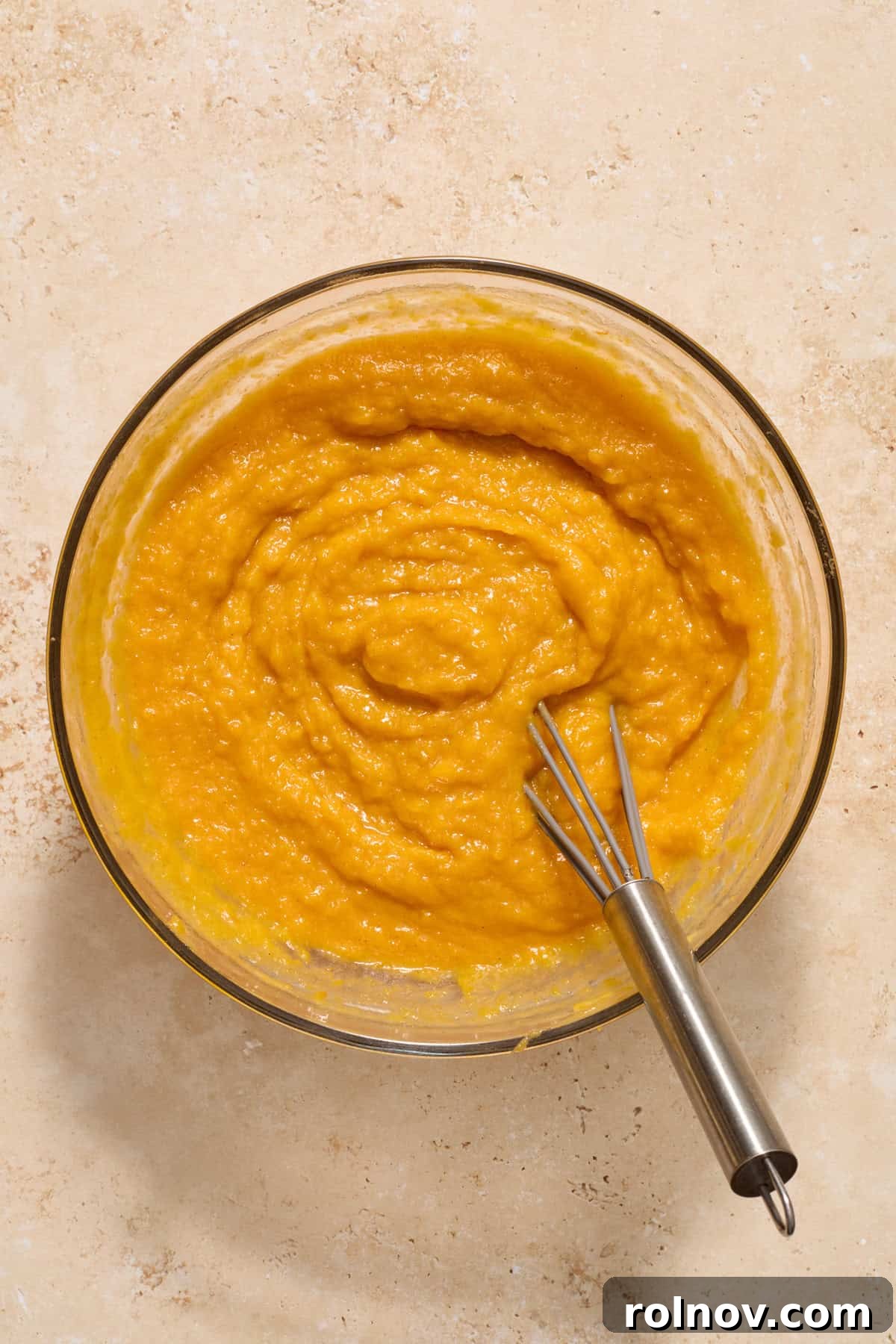 Creamy butternut squash mixture, perfectly whisked, awaiting the crumble topping in a glass mixing bowl.