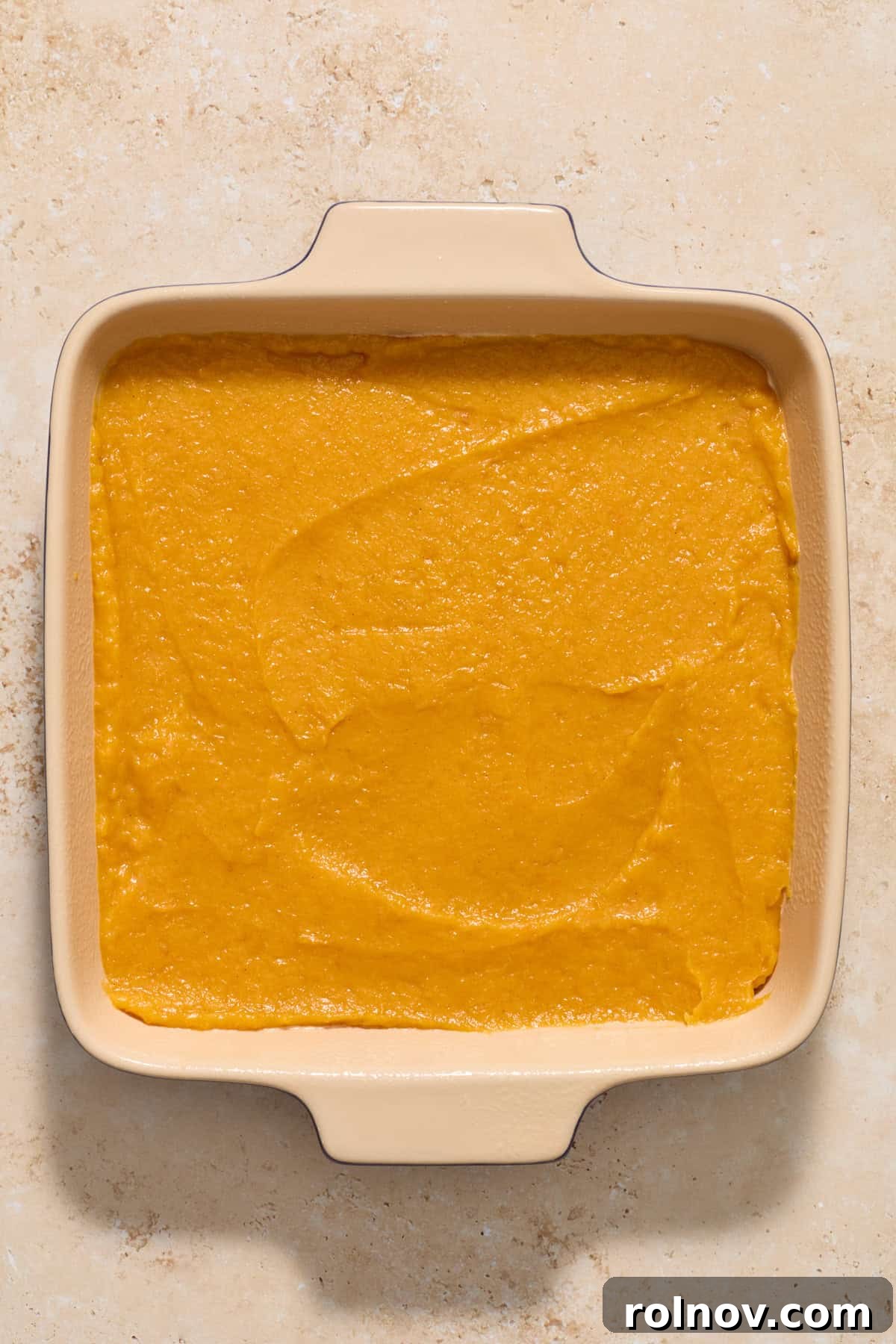 A 9-inch baking pan, buttered and ready, filled with the smooth and creamy butternut squash mixture, spread evenly.