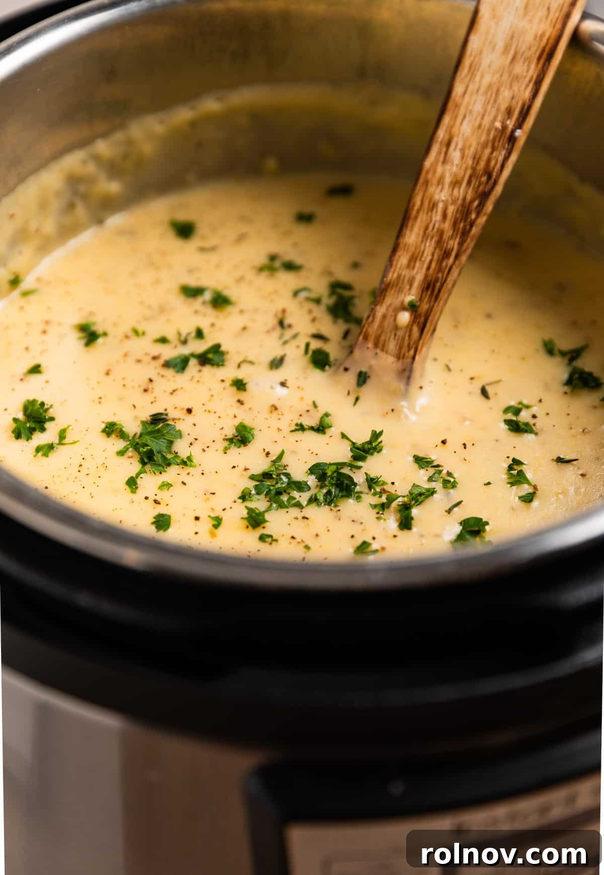 Creamy Instant Pot Potato Leek Soup 7 Instant pot with soup topped with chopped parsley and wooden spoon inserted.