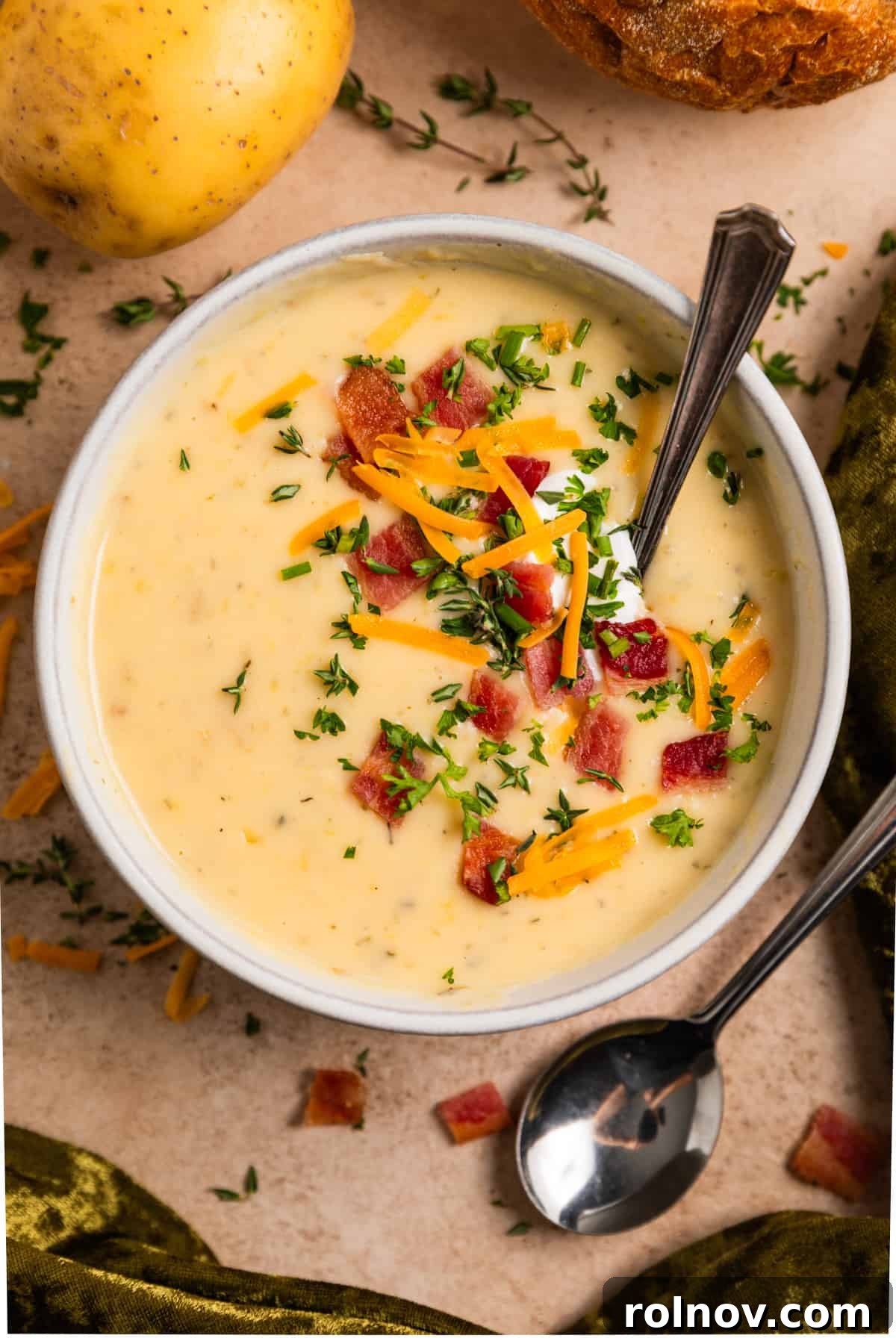 Creamy Instant Pot Potato Leek Soup 8 Overhead view of bowl of potato leek soup with toppings and spoon scooping into the bowl.