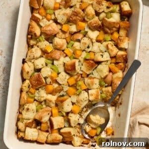 Butternut squash stuffing in pan with serving spoon scooping into the dish.