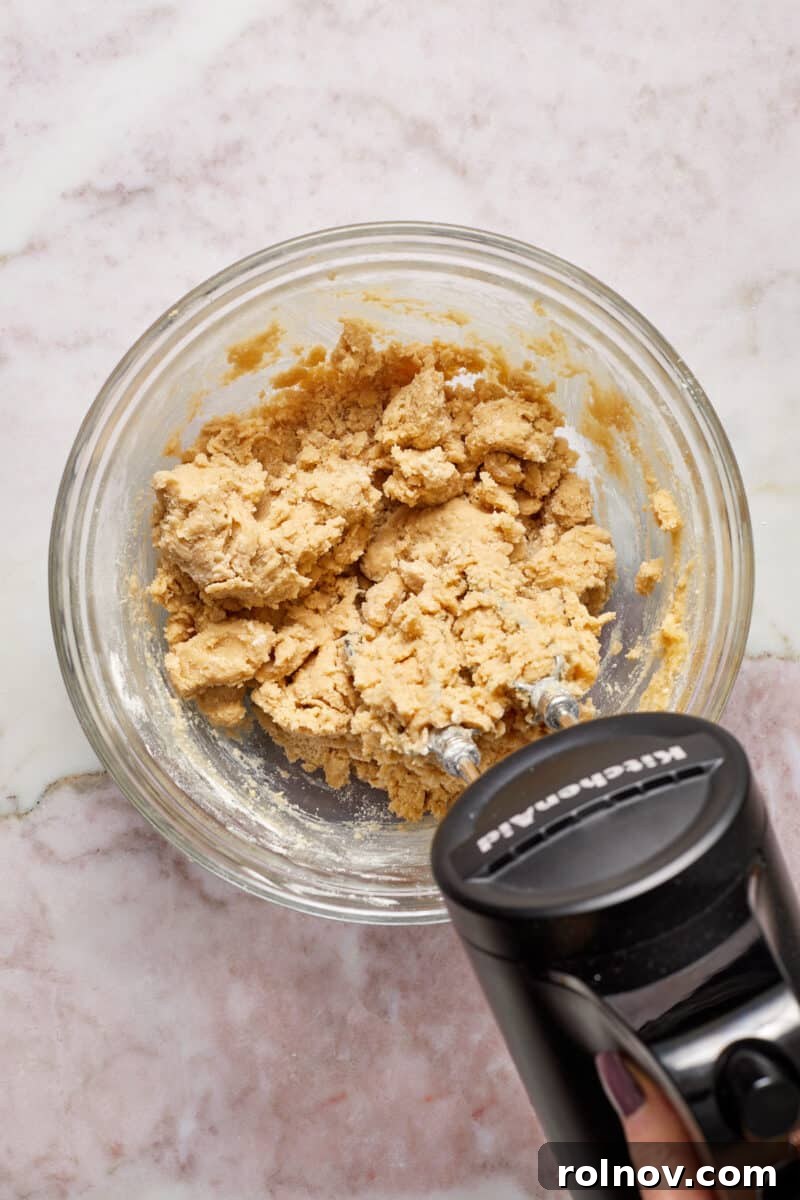 Buttery Holiday Shortbread Delights 6 Flour added and mixed into glass bowl with butter and sugar.