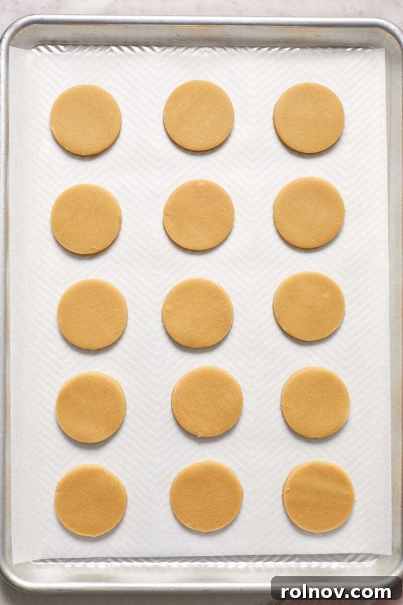 Buttery Holiday Shortbread Delights 10 Cookie cutouts lined on parchment lined baking sheet.