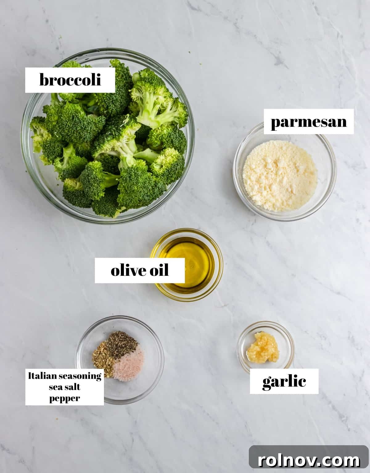 Easy Crispy Air Fryer Broccoli 3 Fresh broccoli florets, olive oil, grated Parmesan cheese, minced garlic, and Italian seasoning laid out on a kitchen counter, ready for preparation.