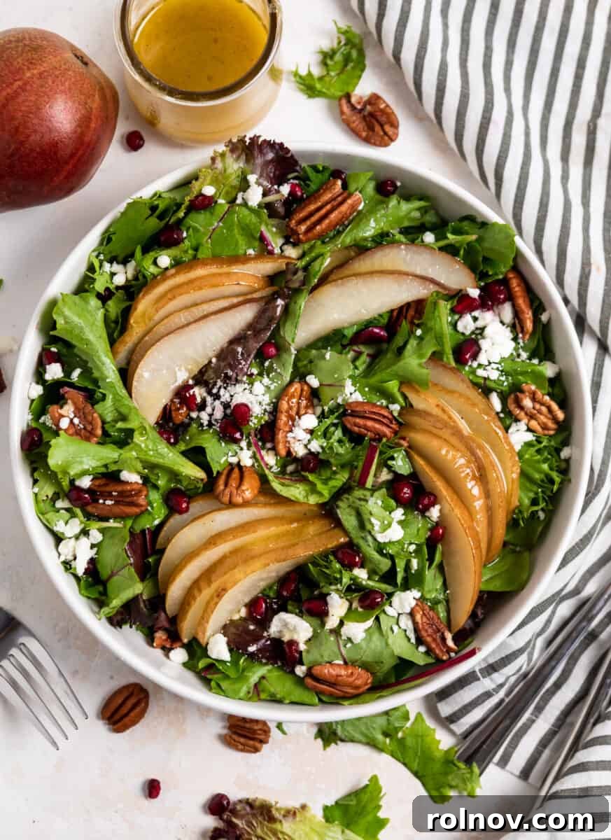 Golden Roasted Pear Salad 6 Overhead view of pear salad in white bowl with dressing and table linen.