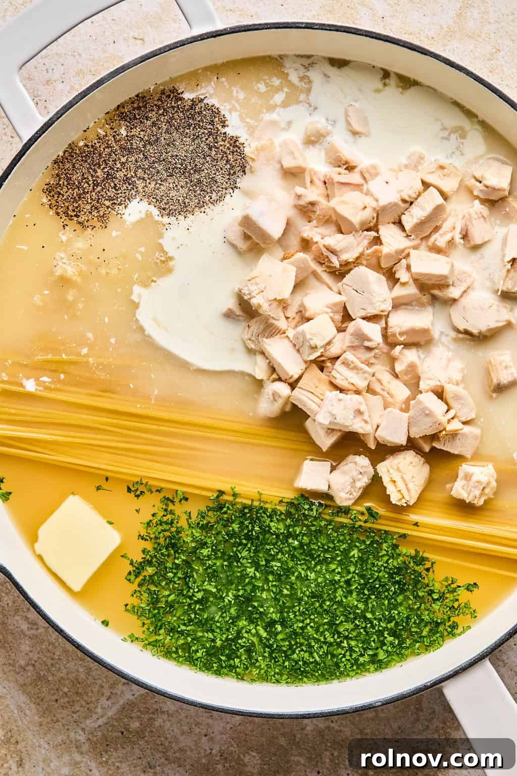 Effortless Creamy Chicken Alfredo 4 Pot with dried pasta, butter, chicken, parsley, cream, and spices.