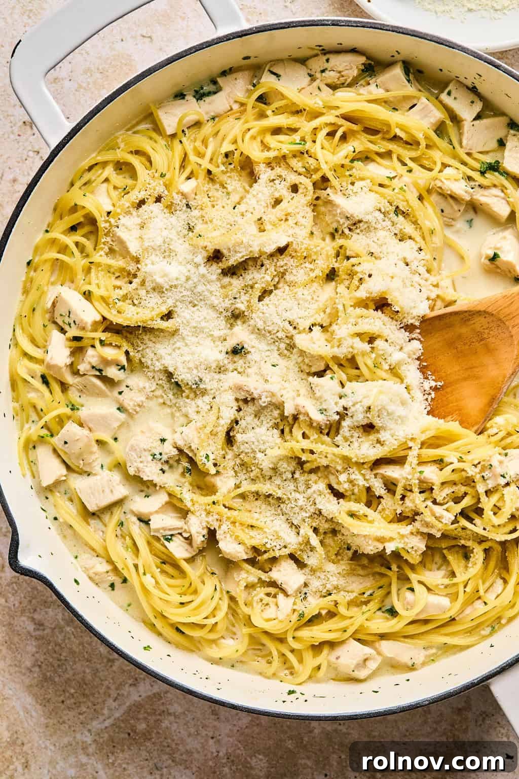 Effortless Creamy Chicken Alfredo 5 Parmesan added to pot with chicken alfredo.