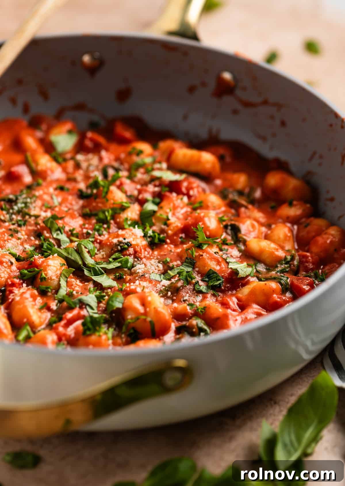 Quick and Easy 15 Minute Tomato Basil Gnocchi 2 Skillet with creamy tomato basil gnocchi topped with Parmesan, fresh basil, and parsley.